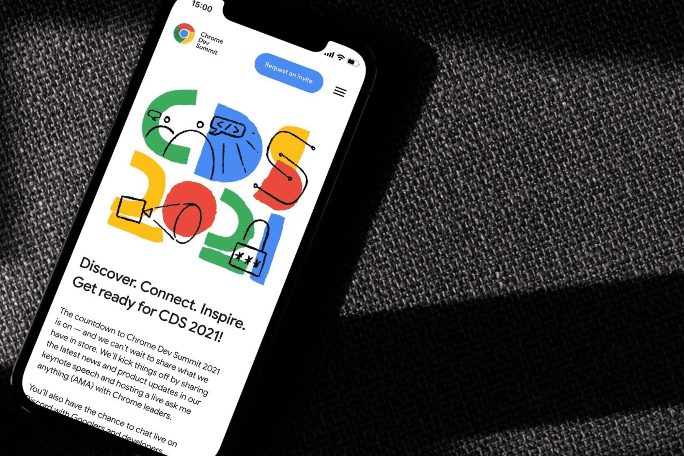 Phone showing the Chrome Dev Summit 2021 site, with hand-drawn CDS 2021 lettering and 'Discover. Connect. Inspire.'